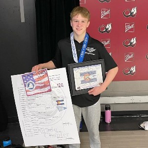 Griffin Rial with his bracket, certificate, and plaque